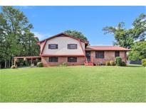 Charming two-story home with a brick facade, large front yard, and a convenient carport at 3510 Spring Valley Blvd, Atlanta, GA 30349