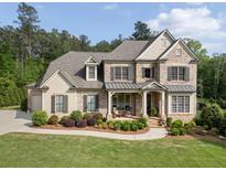 Elegant two-story brick home with a covered front porch and meticulously landscaped front yard at 3024 Malbec Vly, Acworth, GA 30101