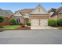 Charming brick home featuring a two-car garage, manicured lawn, and inviting landscaping in a desirable neighborhood at 6355 Glen Oaks Ln, Atlanta, GA 30328