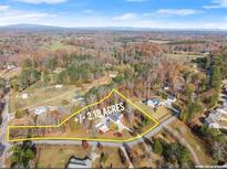 Aerial view of a +/- 2.18 acre lot featuring a charming single-Gathering home surrounded by beautiful fall foliage at 6045 Mockingbird Rd, Cumming, GA 30028