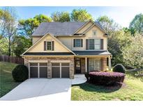 Charming two-story home featuring a two-car garage, manicured lawn, and beautiful stone and siding accents at 2155 Mindy Ln, Cumming, GA 30041