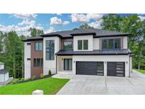 Beautiful two-story home with a modern design, black garage doors, and well-manicured lawn at 165 Westbrook St, Buford, GA 30518