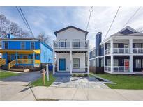 Charming two-story home featuring dual balconies and a vibrant turquoise-colored front door at 962 Welch Sw St, Atlanta, GA 30310