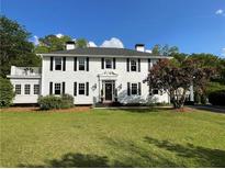 Charming two-story home with a manicured lawn and mature trees providing curb appeal at 6104 Floyd St, Covington, GA 30014