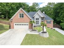 Charming two-story brick home with manicured lawn and two-car garage at 704 Willowwind Dr, Loganville, GA 30052