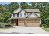 Charming two-story home featuring a stone and siding facade, a two-car garage, and a welcoming front porch at 337 Liberty Dr, Acworth, GA 30102