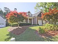 Charming brick home with well-maintained landscaping, two-car garage, and mature trees at 12955 Mariners Ct, Alpharetta, GA 30005