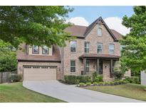 Charming brick two-story home with attached two-car garage and landscaped front yard at 4630 Carriage Walk Ln, Cumming, GA 30040