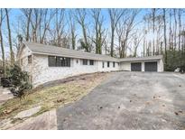 Charming single story brick home with an attached two car garage and long driveway at 5655 Lake Forrest Dr, Atlanta, GA 30342