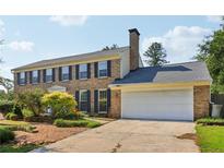 Charming brick home with a well-maintained lawn, mature trees, and an attached two-car garage at 3734 Fox Hills Se Dr, Marietta, GA 30067