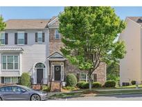 Charming two-story townhome featuring a brick facade, well-manicured landscaping, and a welcoming front entrance at 1257 Park Pass Way, Suwanee, GA 30024
