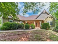 Charming single-Gathering home with stone accents, covered front porch, and mature landscaping at 255 Nicklaus Cir, Social Circle, GA 30025
