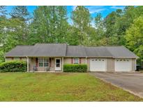 Ranch-style home featuring a front porch and an attached two-car garage, set on a lush green lot at 161 Gann Cemetery Rd, Dallas, GA 30157