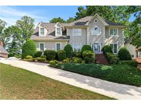 Beautiful two-story home with mature landscaping, dormer windows, and light-colored facade at 1775 Potomac Ct, Lawrenceville, GA 30043