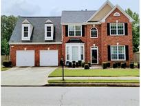 Charming brick home with a well-manicured lawn and a two-car garage at 3703 Liberty Sw Dr, Powder Springs, GA 30127