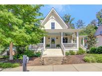 Charming two-story home with a welcoming front porch and manicured landscaping at 11190 Serenbe Ln, Chattahoochee Hills, GA 30268