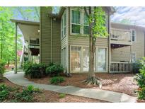 Charming multi-level home with wood siding, balconies, and a beautifully landscaped walkway through the trees at 602 Country Park Se Dr, Smyrna, GA 30080