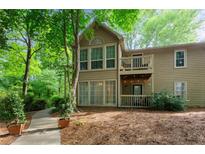 Charming exterior view with a deck, balcony, lush landscaping, and a welcoming pathway at 602 Country Park Se Dr, Smyrna, GA 30080