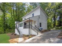 Charming two-story home with white siding, dark railings, and a beautifully landscaped yard at 1080 Westmont Sw Rd, Atlanta, GA 30311