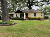 Charming yellow home with landscaped front yard, lovely shrubbery and manicured lawn at 5760 Brenda Sw Dr, Mableton, GA 30126