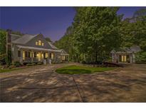 Inviting covered porch with comfortable seating, a ceiling fan, and stone steps amidst lush landscaping at 8901 Watkins Mill Rd, Winston, GA 30187