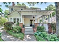 Charming two-story home featuring a welcoming front porch with brick columns and professionally landscaped yard at 1157 Alta Ne Ave, Atlanta, GA 30307