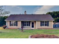 Charming single-story home with a well-maintained lawn, classic shutters, and neutral siding at 943 Colvin Dr, Locust Grove, GA 30248
