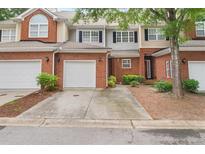 Attractive brick townhome featuring an attached garage, well maintained landscaping, and inviting curb appeal at 59 Townview Dr, Alpharetta, GA 30022