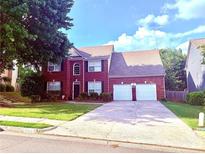 Traditional two-story brick home with a two-car garage and well-maintained landscaping at 6005 Baywood Dr, Roswell, GA 30076