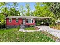 Cozy, red brick single story home featuring a large covered carport and landscaped front yard at 823 Catherine St, Forest Park, GA 30297