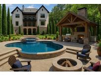 Stunning backyard featuring a pool, jacuzzi, fire pit, outdoor kitchen, and a covered patio with a fireplace at 10765 Shallowford Rd, Roswell, GA 30075