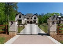 Stunning two-story home with black metal gate and pristine landscaping at 10765 Shallowford Rd, Roswell, GA 30075