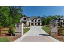 Elegant home with a private driveway, stone accents, manicured lawn and lush landscaping at 10765 Shallowford Rd, Roswell, GA 30075