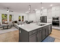 Modern kitchen with an island, stainless steel appliances, and an open concept to the dining and living room at 1070 Harper Dr, Alpharetta, GA 30076