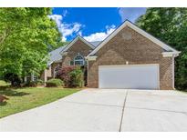 Charming brick home with a two-car garage and a well-manicured front yard beneath a blue sky at 3314 Dilmus Dr, Powder Springs, GA 30127