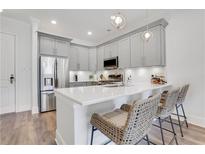 Bright kitchen features gray cabinets, stainless appliances, pendant lighting, and a breakfast bar with seating at 1055 Piedmont Ne Ave # 409, Atlanta, GA 30309