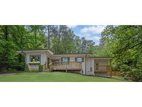 Beautiful house with a front porch, surrounded by mature trees and lush landscaping at 1839 Belcher Pl, Austell, GA 30168