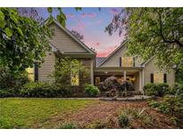 Charming home showcasing lush landscaping, stone accents, and inviting front porch under a pastel dusk sky at 1495 Old Hunters Lake Dr, Marietta, GA 30062