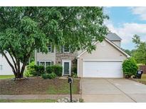 Charming two-story home featuring stone accents, a two-car garage, and a well-maintained landscaped front yard at 3230 Deer Valley Nw Dr, Acworth, GA 30101