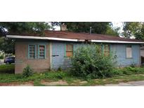 View of a neglected single-story home, showing peeling paint and overgrown bushes at 868 Oakhill Sw Ave, Atlanta, GA 30310