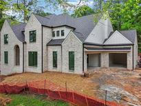 New construction home with white painted brick, black window trim, and two-car garage at 1145 Kingston Drive, Atlanta, GA 30342