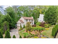 Charming traditional home featuring lush landscaping, a two-car garage, and a serene, wooded backdrop at 1434 Churchill Way, Marietta, GA 30062