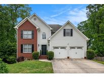 Charming two-story home with brick and siding, featuring an attached two-car garage and well-manicured lawn at 3073 Hopeland Dr, Powder Springs, GA 30127