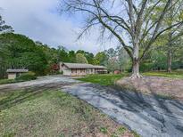 Charming single-Gathering home featuring a cozy front porch and beautiful landscaping in a lush, green setting at 4445 Moon Station Nw Ln, Acworth, GA 30101