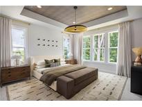 Bright primary bedroom featuring a statement ceiling, large windows, and stylish furnishings at 1432 Wicker Wood Se Pl # 9, Smyrna, GA 30080