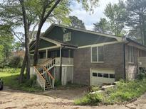 Charming home featuring a brick facade, second-story porch, stairs, and two-car garage at 2256 Mack Rd, Douglasville, GA 30135