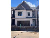 New construction townhome featuring a two-car garage and neutral brick facade, and contrasting trim at 3104 Marbella Cir # 2, Kennesaw, GA 30152