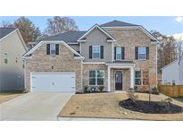 Charming two-story brick home with a two-car garage and well-manicured front yard at 1147 Trident Maple Chase, Lawrenceville, GA 30045