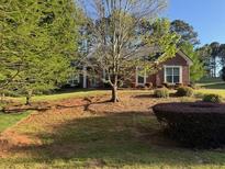 Beautiful brick home featuring a well-manicured lawn and mature trees at 240 Huiet Dr, Mcdonough, GA 30252