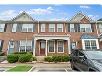 Charming brick townhome with well-maintained landscaping and covered entryway at 274 Paden Cove Trl, Lawrenceville, GA 30044